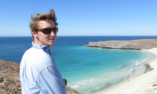 Robert on a cliff overlooking a sandy beach