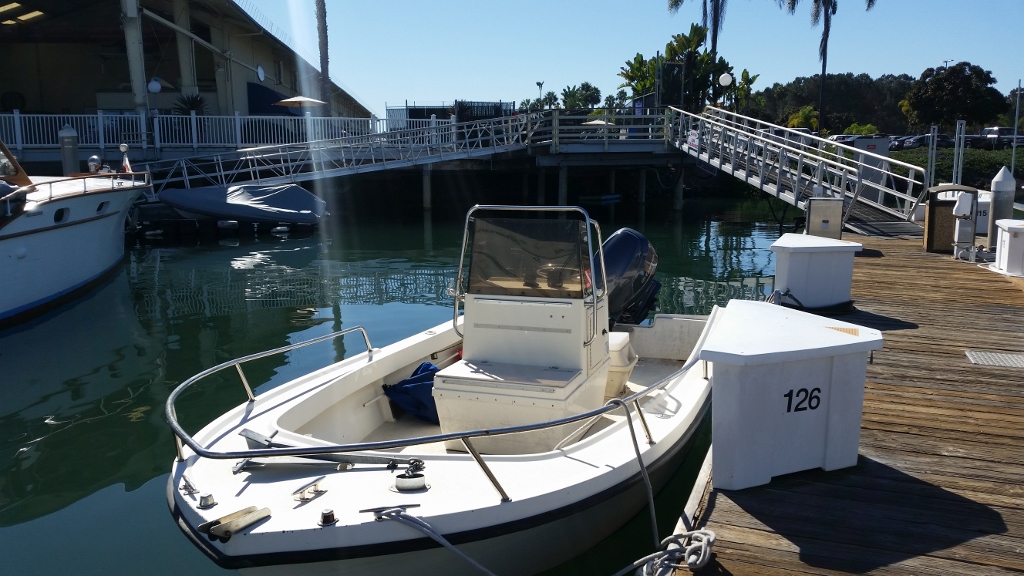 21' open bow, center console driven boat docked at on a floating pier